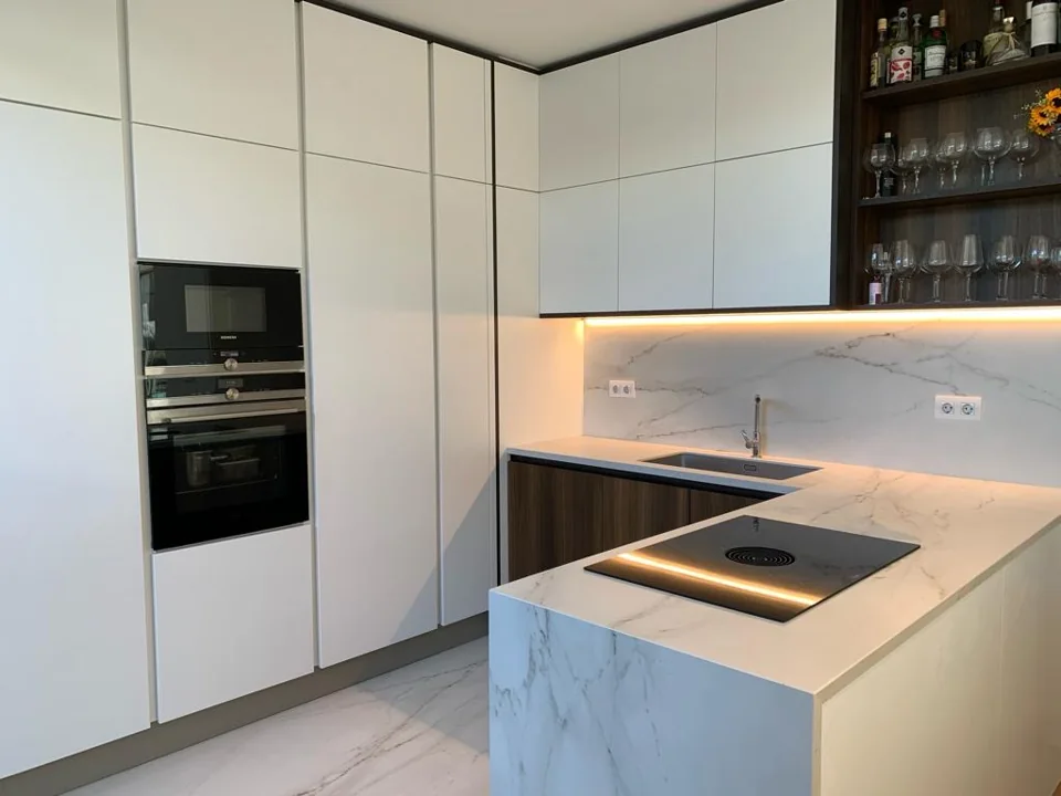 Cozinha com armários claros e iluminação integrada