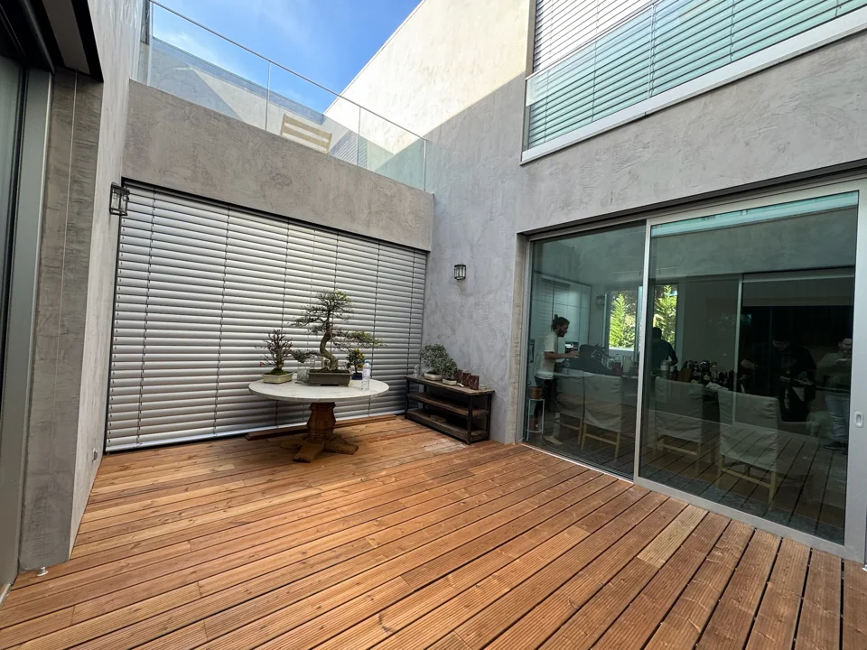 Pátio com deck de madeira junto a portas envidraçadas